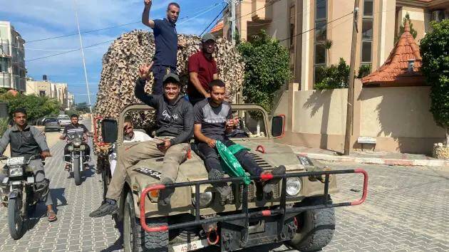 Палестинцы празднуют, проезжая на израильской военной машине